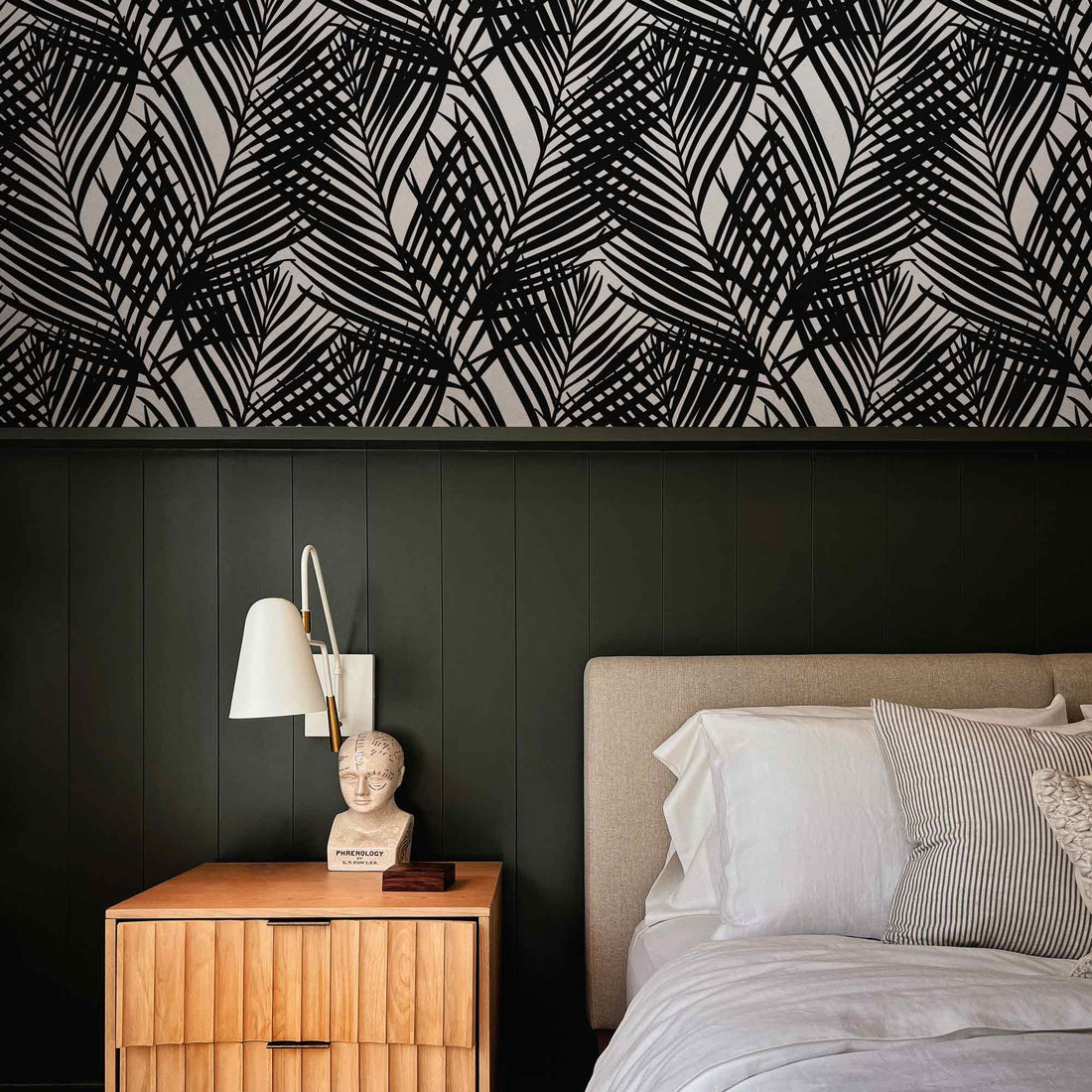 tropical style bedroom interior with black and white palm leaves print wallpaper