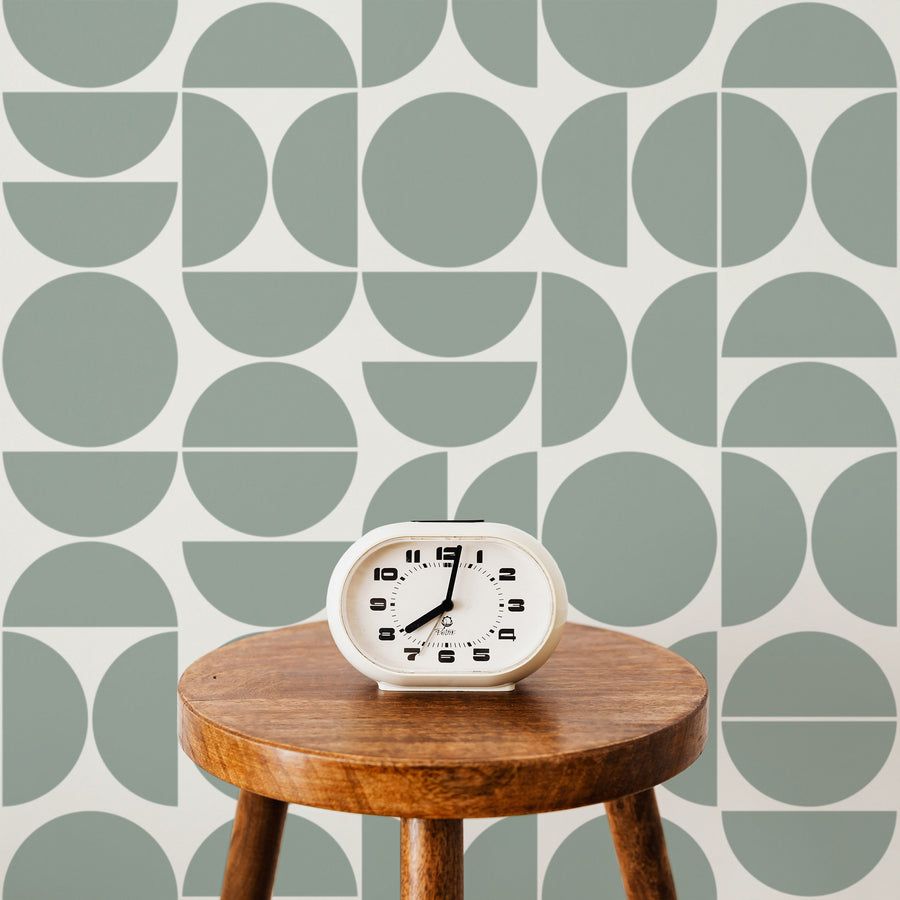 green and white geometric circes wallpaper with a stool