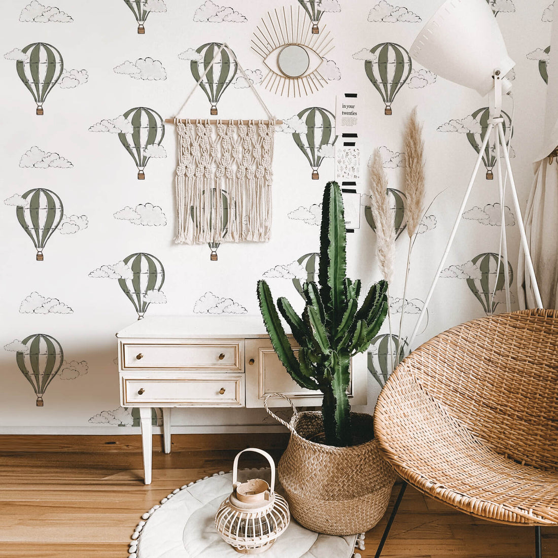 Khaki green watercolor air balloon removable wallpaper in boho interior with cactus and rattan furniture 