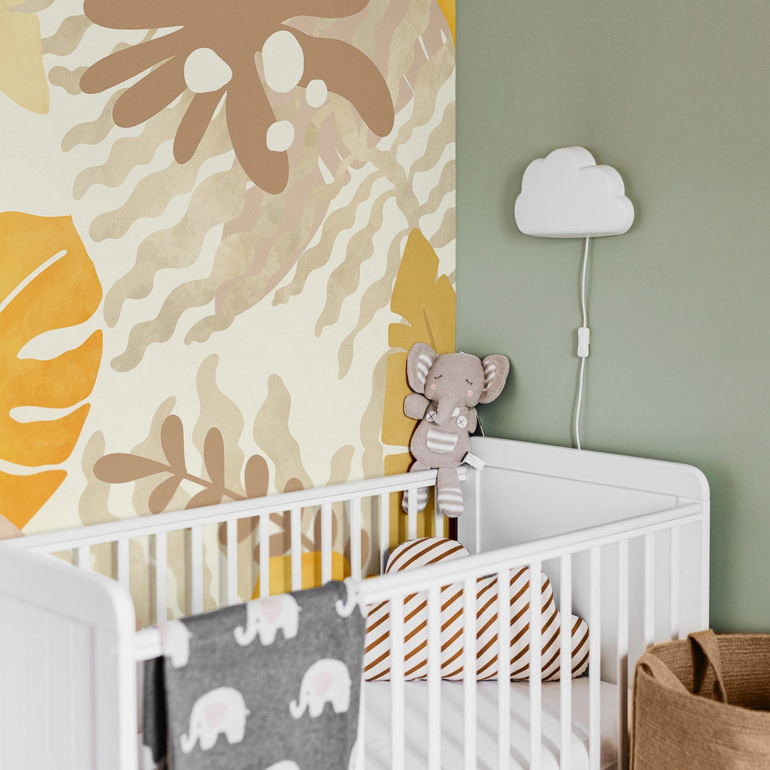 Jungle theme nursery interior with neutral tropical wall mural and safari animals decor and toys