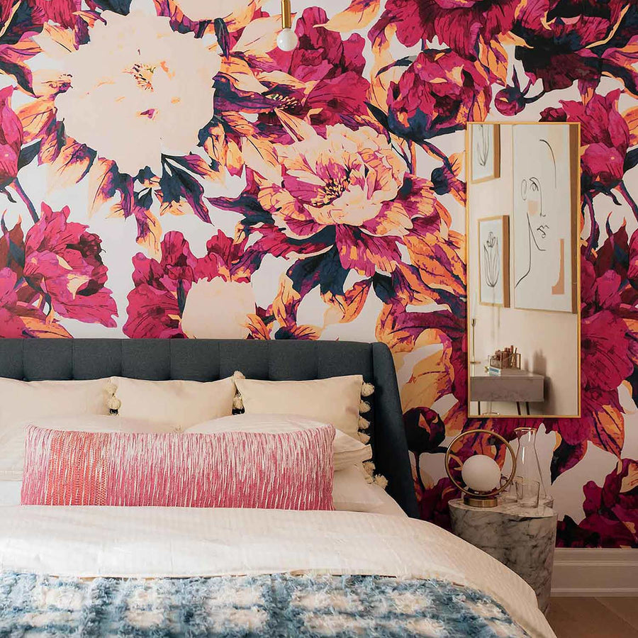 bold pink guest bedroom with floral accent wall behind bed