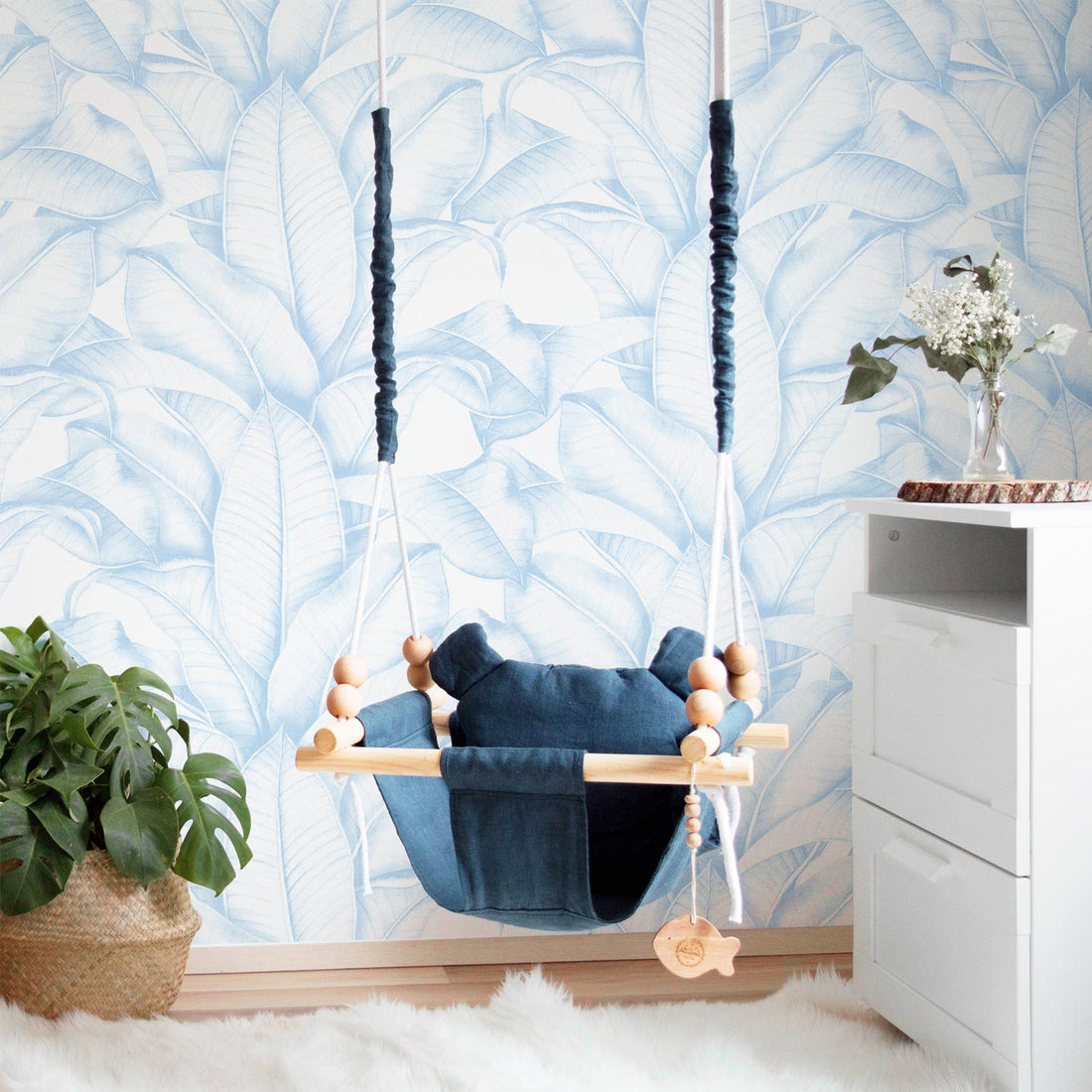 large scale botanical leaves print wallpaper in blue for baby nursery interior