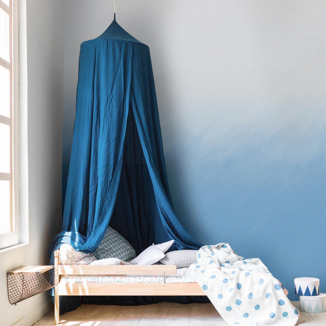 small kids bedroom interior with blue canopy bed detailing and ombre wall mural