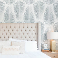Light coastal style bedroom interior with blue palm leaf wallpaper