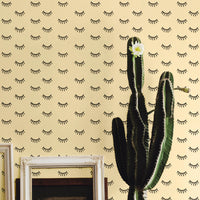 Boho girl's room interior with flowering cactus and sleepy eyes removable wallpaper in yellow and black color